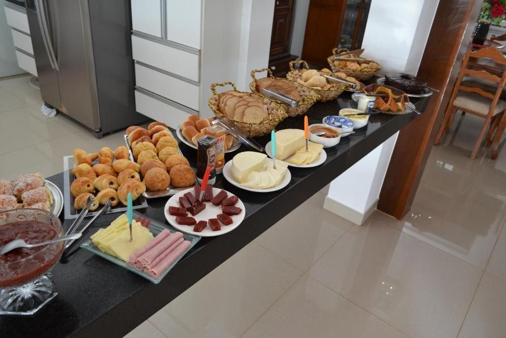 Bancada do café da manhã com pães, frios e frutas